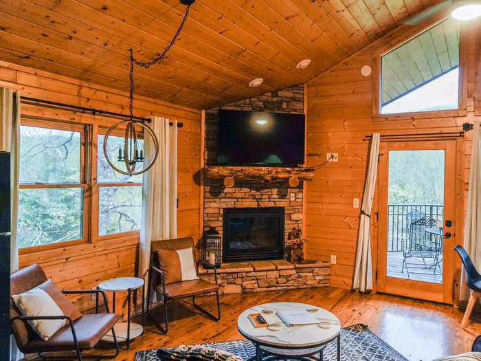 Past the kitchen, the living area seemed to have all the components of a cozy night in: a comfy couch, a TV mounted above a fireplace, and vast windows with views of the surrounding natural area.