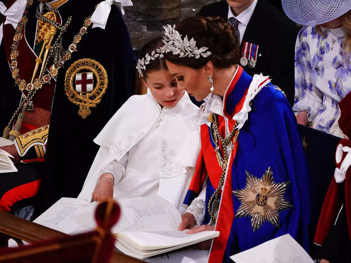 Princess Charlotte seemed a little more engaged. Turning to her mother, she pointed to something written in the ceremony