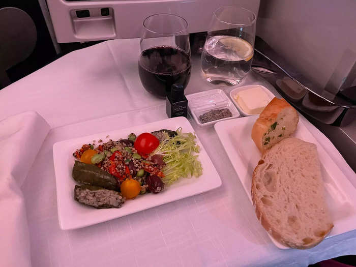 My dinner in business class felt like fine dining. I had cloth napkins, metal cutlery, and ceramic plates. A flight attendant stopped by and offered me three choices of warm bread along with a little tray of salt, pepper, and olive oil.