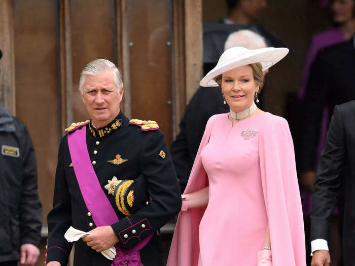 King Philippe of Belgium wore a magenta sash over his military regalia. His wife, Queen Mathilde, opted for a pastel pink caped dress and matching leather gloves.