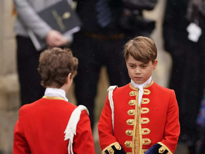 As a page of honor, Prince George wore a scarlet red coat with gold embroidery and white gloves.