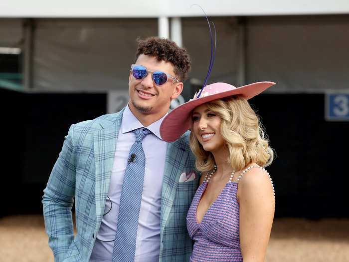 Brittany Mahomes posed with her husband, Kansas City Chiefs quarterback Patrick Mahomes, in a simple pink hat decorated with a tall, purple feather.