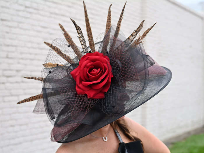 Another guest wore a black hat full of interesting details, including feathers, mesh, and a large red rose as its centerpiece.