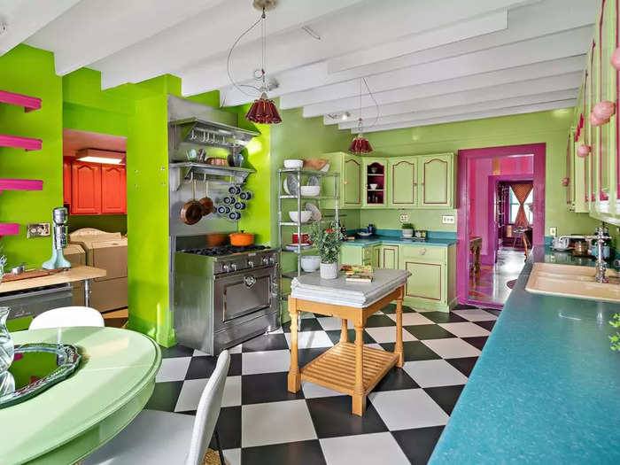 The green cabinets sport pink trim and pink doorknobs that carry on the house