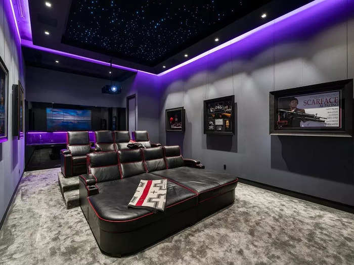 The front row includes chaise-like theater seats. The "Scarface" poster on the right is a nice touch for a theater room in Miami.
