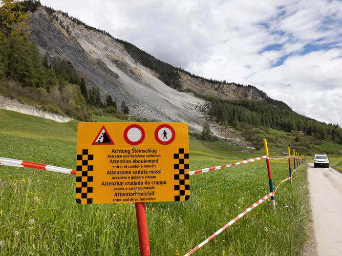 Barriers blocked off roads and a sign under a portable traffic light read: "Extreme danger of rockfall when red."