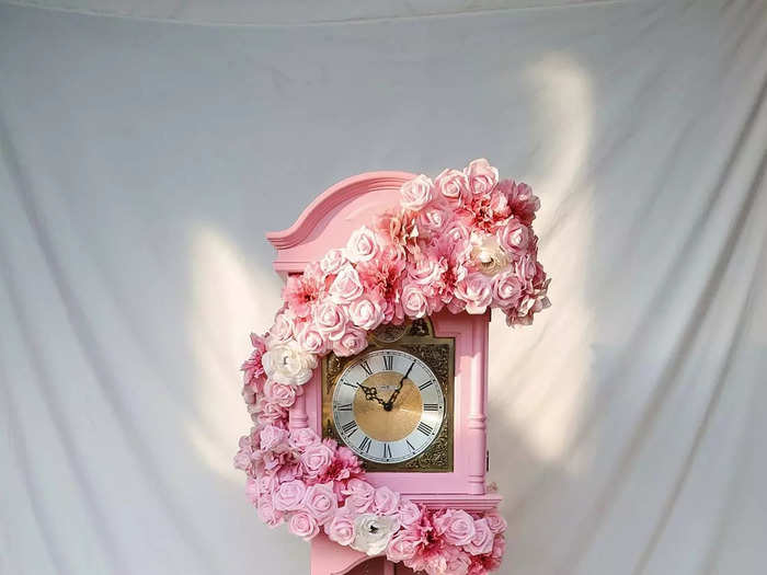 The finished clock painted pastel pink with a ribbon of pink flowers cascading down