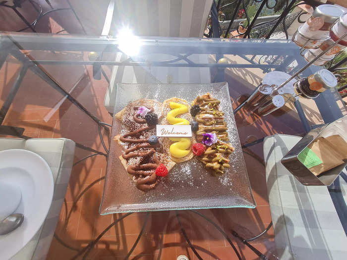 A server later arrived with a complimentary plate of pancakes, crêpes, and waffles, with a tiny "welcome" sign on top.