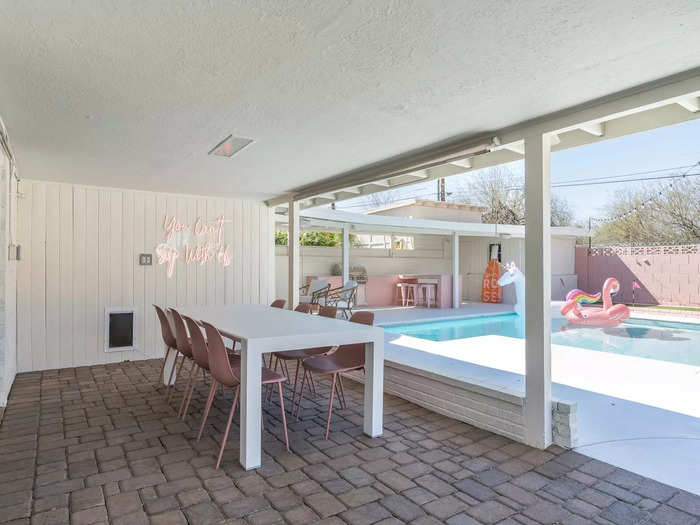 The pink color scheme continued outside, as the covered patio features a large dining table with pink chairs.