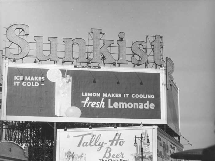 Advertisements for cold beverages like Sunkist and Tally-Ho Beer lined the boardwalk.