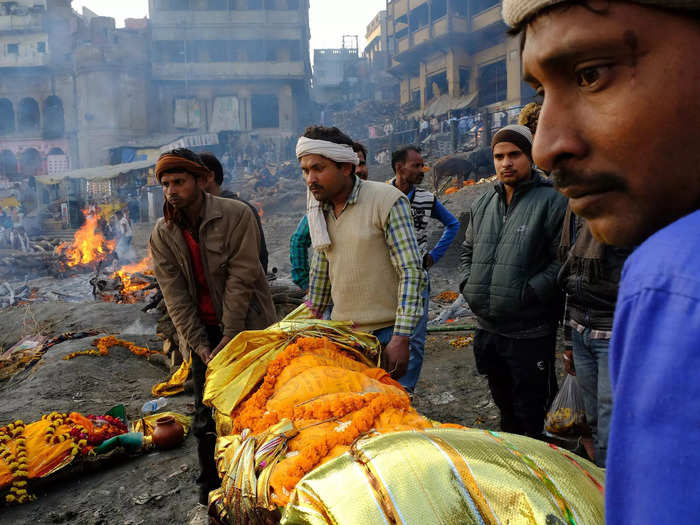 When someone does die in Varanasi, their body is wrapped — usually in white — and adorned with marigolds. Here the person has been wrapped in gold.