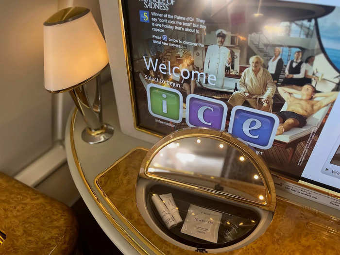 Another table sits below the television, complete with a mirror, toiletries, and a lamp…