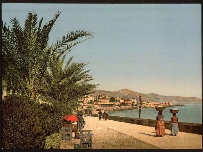 Women walk along the waterfront promenade in Sanremo.