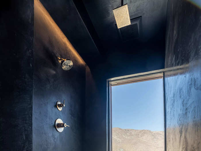 The shower has a large window that offers views of cacti and the Joshua Tree desert.