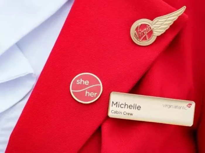 The uniforms have not changed, but the airline has abolished the "male" and "female" categories and introduced optional pronoun badges.