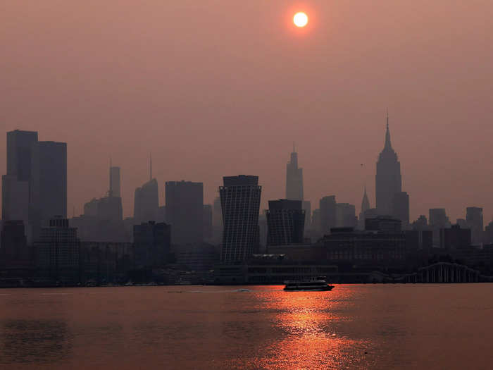 The sun reflected through the smoke onto the Hudson River in New York, creating an orange-red glow on the water.