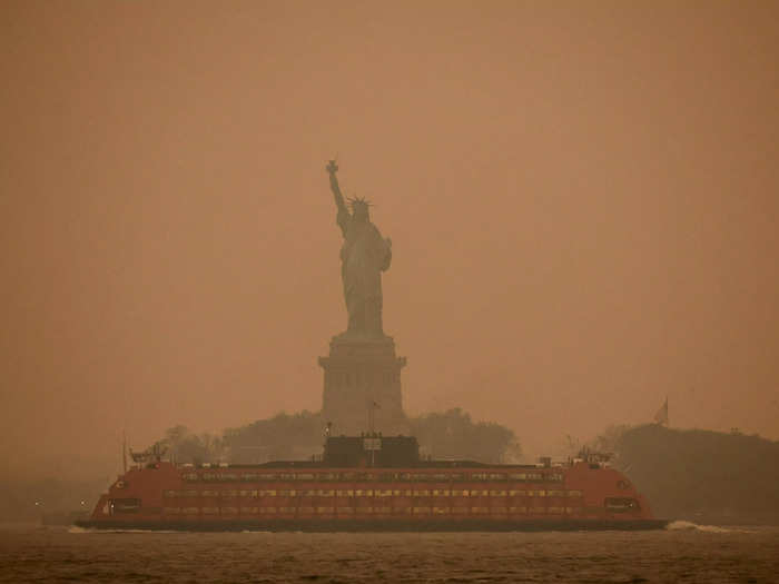 In New York City, the Statue of Liberty was shrouded in haze as a commuter ferry passed.