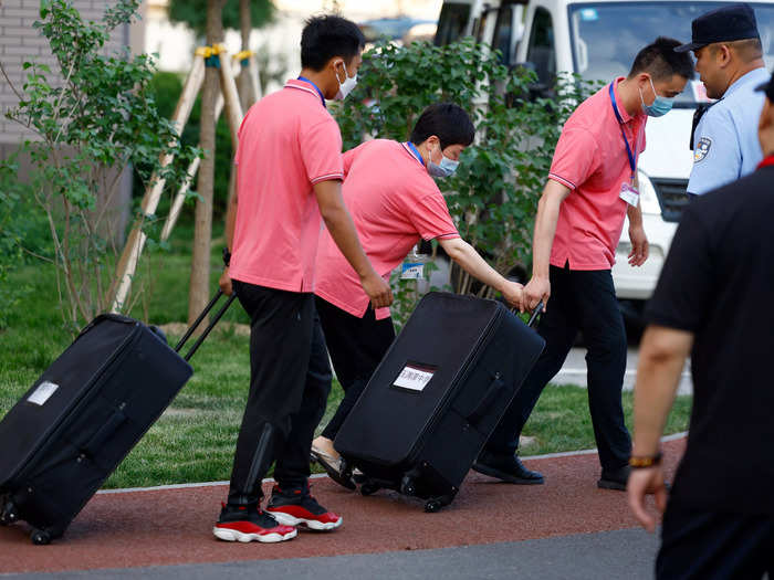 The exam papers have to be kept secure too. Staff members at this exam center in Beijing are moving the documents in suitcases under the watch of local guards.