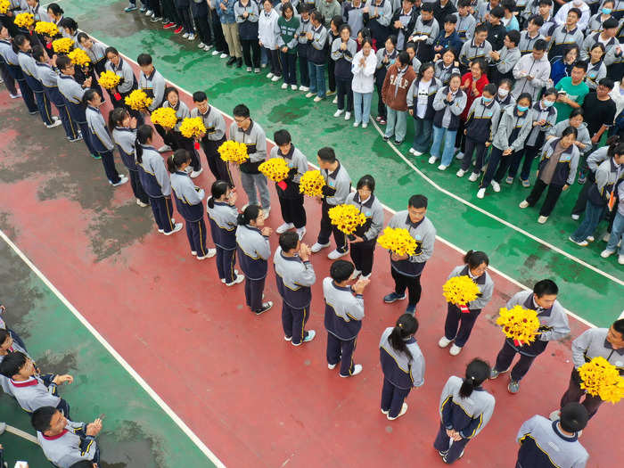 Younger students are often asked to cheer on their seniors, like at this ceremony in Xuzhou, where test-takers received paper sunflowers from their schoolmates a day before this year