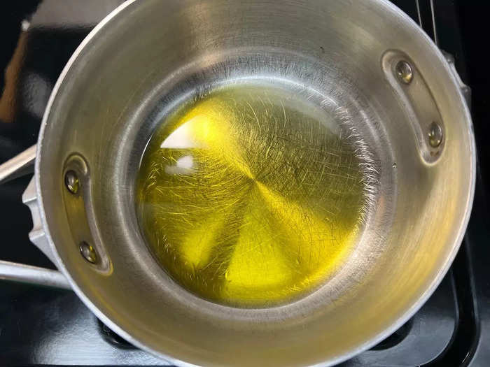 First, heat your olive oil in a deep pan on medium-high heat. Pour as much oil as it takes to cover the bottom of the pan.