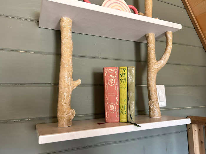 The faux branches connecting the floating shelves were so cool, and I liked how the colorful books looked against the wall.