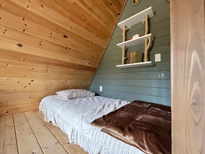 One of the beds has a small bookshelf above it.