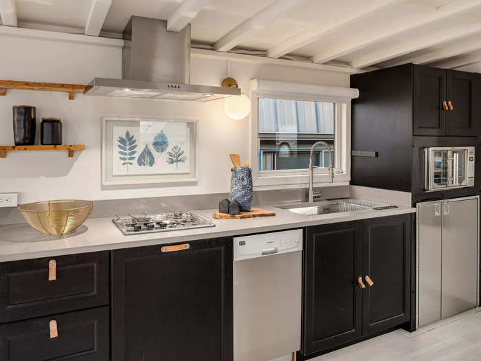 It has quartz countertops and stainless-steel appliances, including a dishwasher and a small fridge.