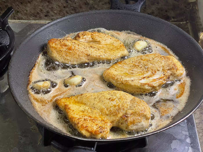 Place the chicken in the pan and let it sizzle.