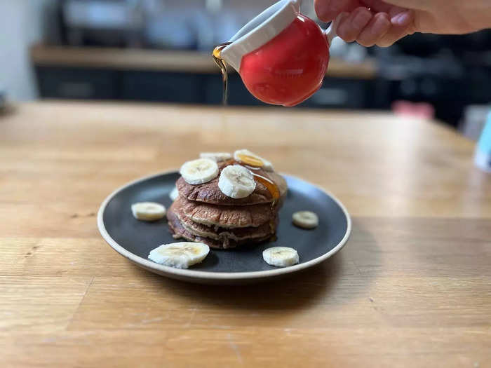 As I made the pancakes, I kept them warm on a plate under foil. Then I piled four pancakes on a plate — the recipe suggests three per serving, but I was hungry — and topped them with banana and maple syrup.