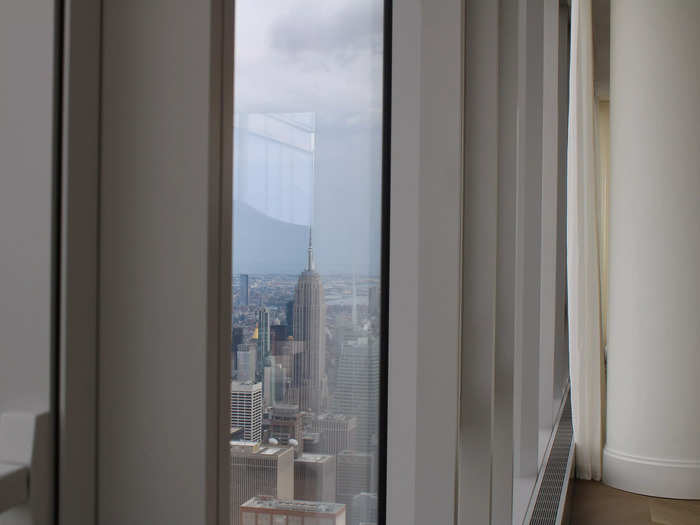 Looking out the floor-to-ceiling windows that wrapped around the spacious living area, the tops of the city