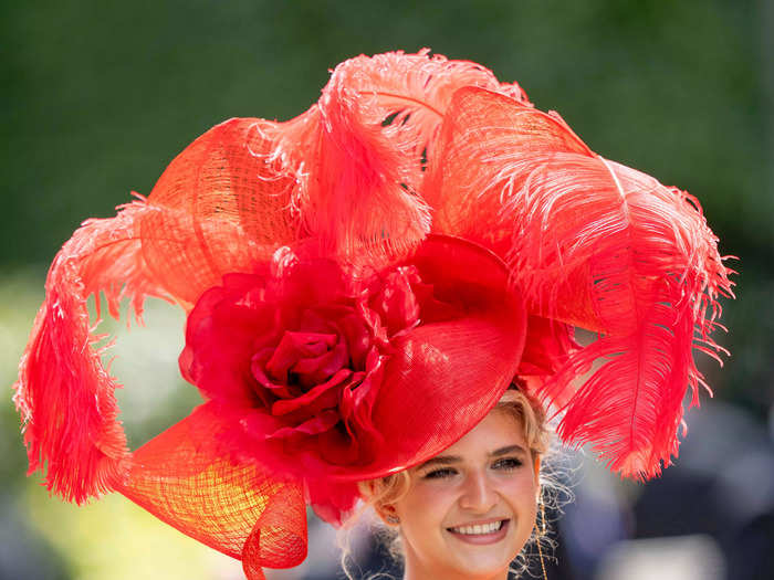 Another attendee wore a bold red fascinator with large red feather plumes.