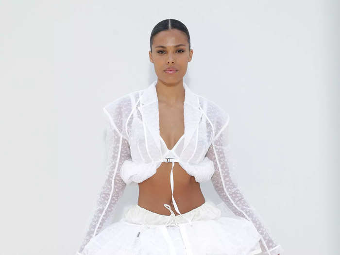 Tina Kunakey paired a semi-sheer, cropped jacket with a voluminous miniskirt to attend the fashion show.