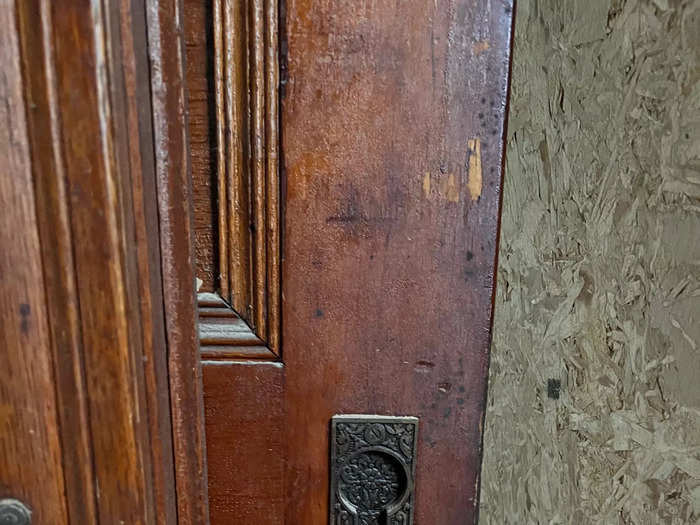 A detailed metal keyhole in a wooden door.