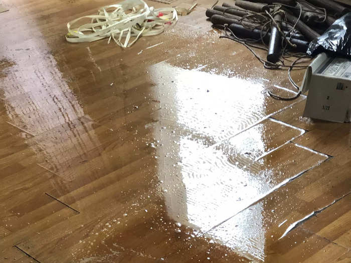 A puddle from rain in the living room of a house.