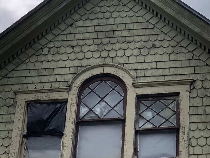 An exterior view of the top floor of an abandoned house.