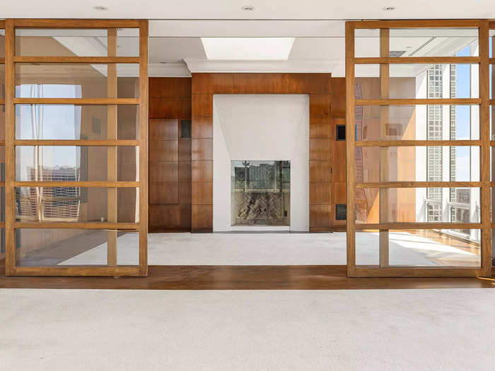 Sliding doors opening up to an empty penthouse library.