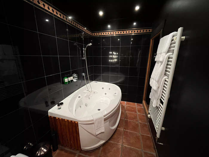 The spacious bathroom, decorated with sleek black wall tiles, included a whirlpool tub.