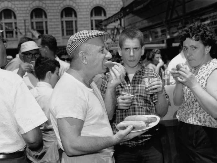 The first-ever winner of the contest was an Irish immigrant who ate 13 hot dogs and buns. In this photo from 1961, an unidentified man eats a Nathan