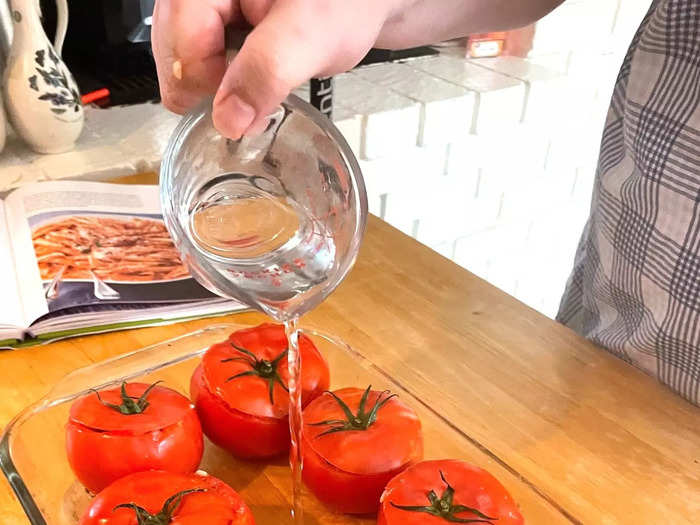 Then put the tops back on the tomatoes and add some water and olive oil.