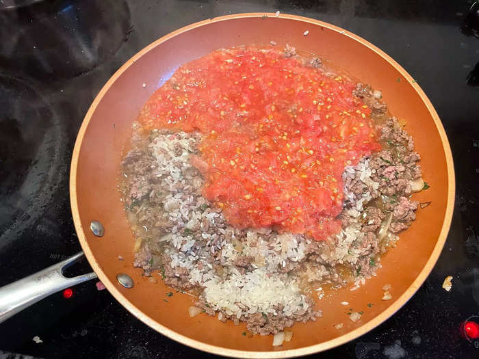 Once the meat has browned, add the rice and tomato "sauce."