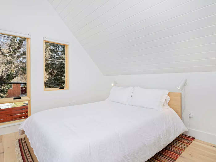 The bedroom has several windows and a cape ceiling.