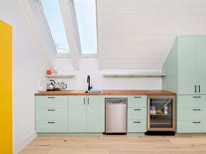 The whole unit is not just filled with light but also bright color. The cabinetry is aqua, including a refrigerator that blends in.