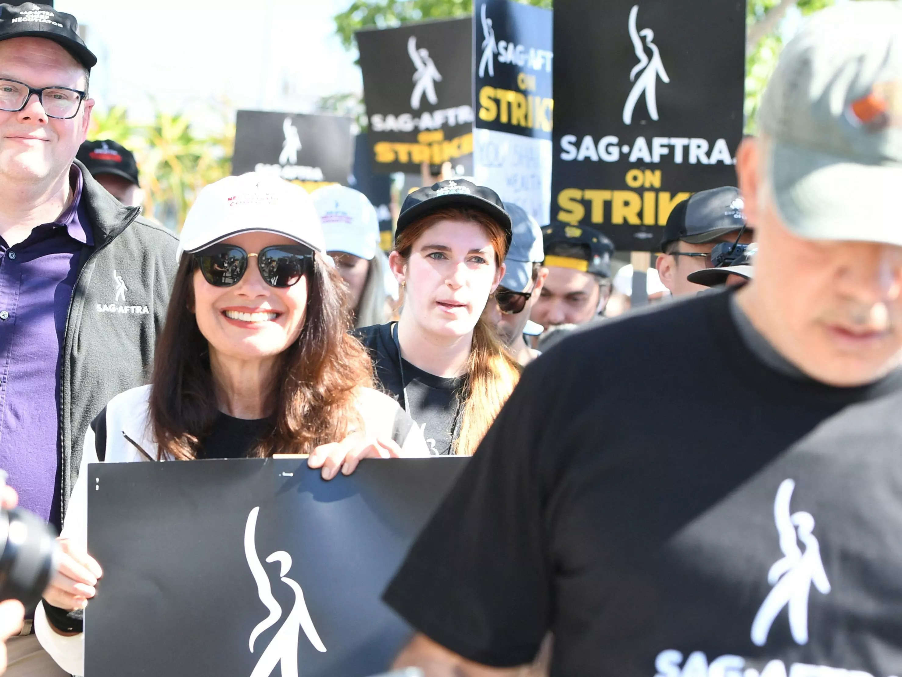 Actors on strike in SAG-AFTRA strike holding picket signs