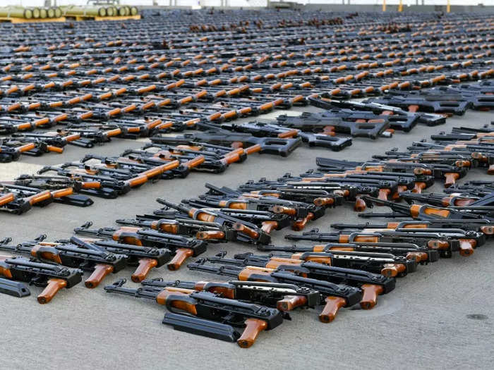 Rows of Chinese-made assault rifles are laid out for the photo op.