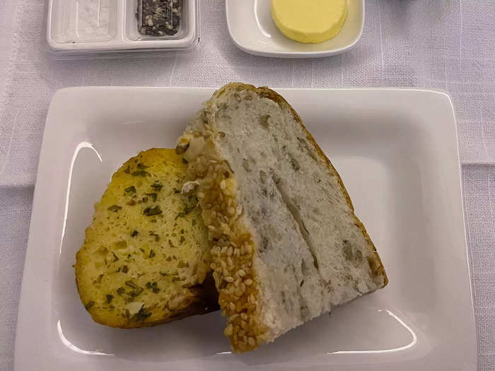 The first thing I ate in business class was bread. A flight attendant came around offering three types: sourdough, garlic, and olive. Naturally, I tried one of each.