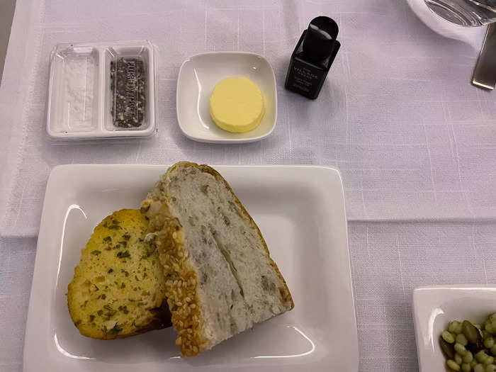 Meanwhile, in business class, the meal was an experience. Before delivering my first course, a flight attendant laid down a cloth napkin, a ceramic tray with salt and pepper, silverware, and an individual-sized olive oil on my tray table.