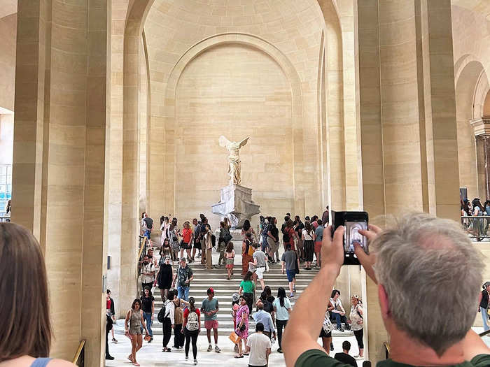 Inside the museum, people milled around the Winged Victory of Samothrace, an iconic statue situated at "one of the most emblematic spots" in the Louvre.