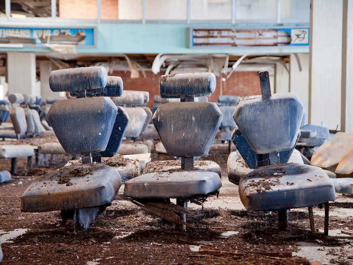 In other areas of the airport, dust and dirt cover crumbling chairs.