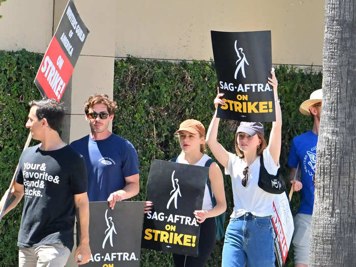 The pair, along with actor Kaitlyn Dever, held their SAG-AFTRA on strike signs in unison while walking the picket line.