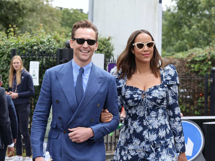 Tom Hiddleston and Zawe Ashton wore coordinating blue outfits by Ralph Lauren. Ashton wore a tea-length dress with a floral print, sweetheart neckline, and scrunched shoulders, while Hiddleston wore a dapper navy suit with oversized lapels on the jacket.